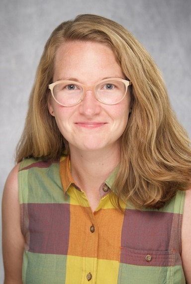 Caitlin Owens - portrait photo with plaid shirt