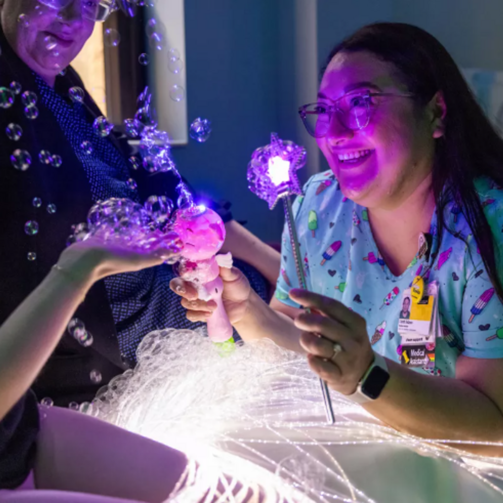 Medical assistant distracts young patients in the vaccine clinic