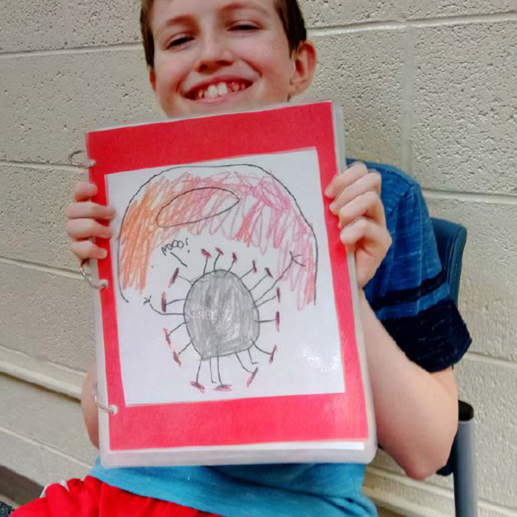 Cash Boles holds up his book about Covid