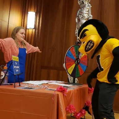 Herky learns from UCEDD student worker, Megan Mindy, how to play the “Interruption Game”