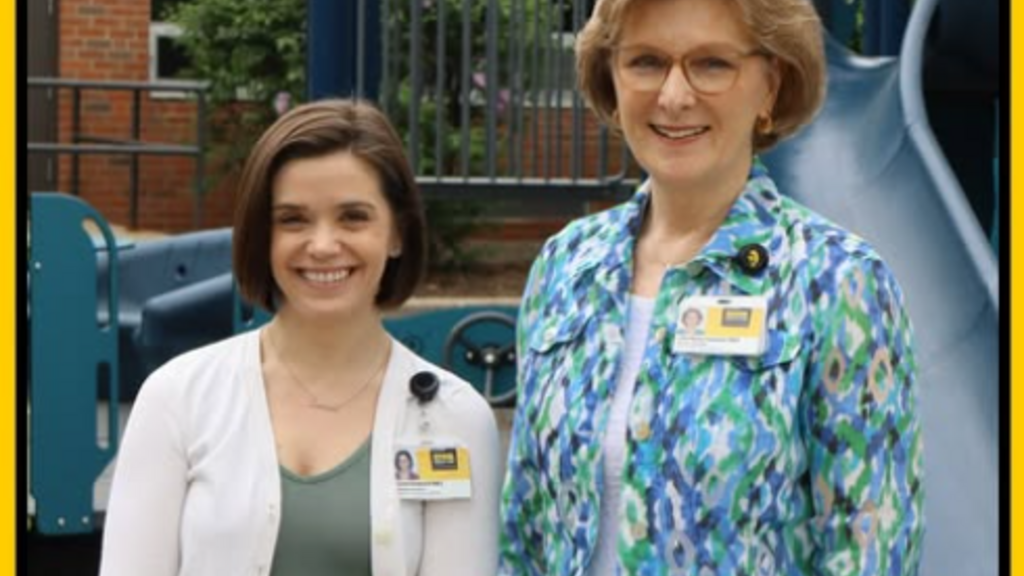 Jenna Prescott and Lisa Henry Vasquez, CDD educational diagnosticians, stand together in the CDD courtayrd by the accessible playground equipment